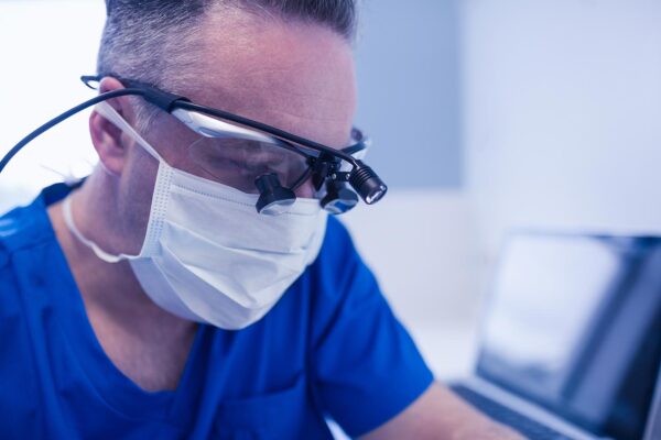 dentist or surgeon working with loupes and light on