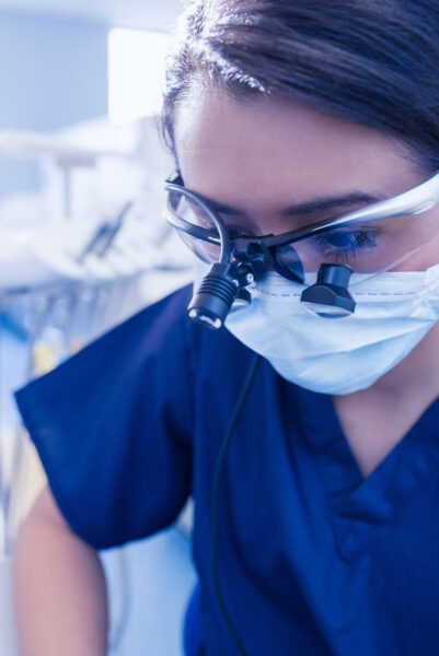 A female surgeon working with TTL loupes and LED light